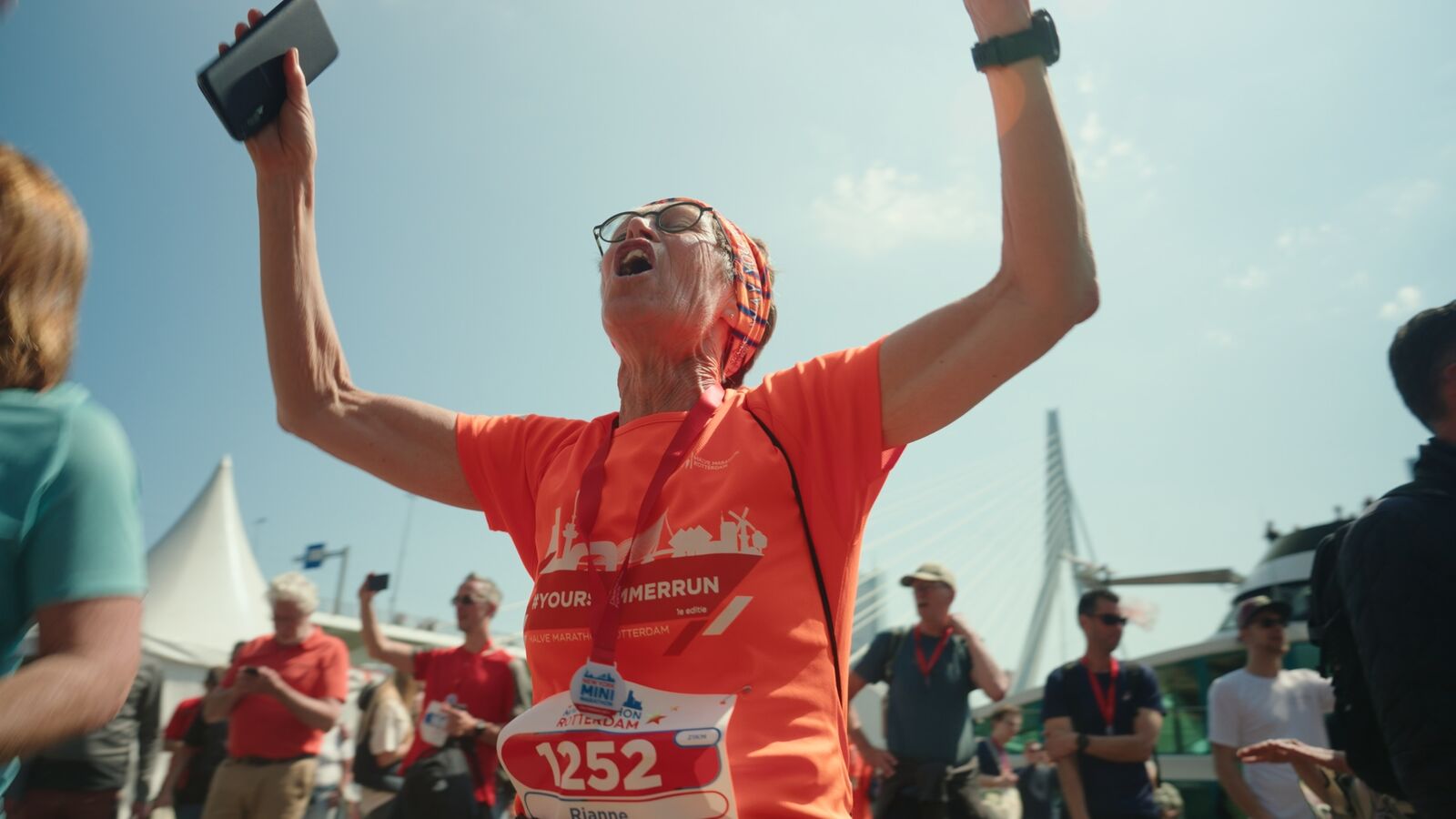 Still uit de aftermovie — juichende loper met de Erasmusbrug op de achtergrond