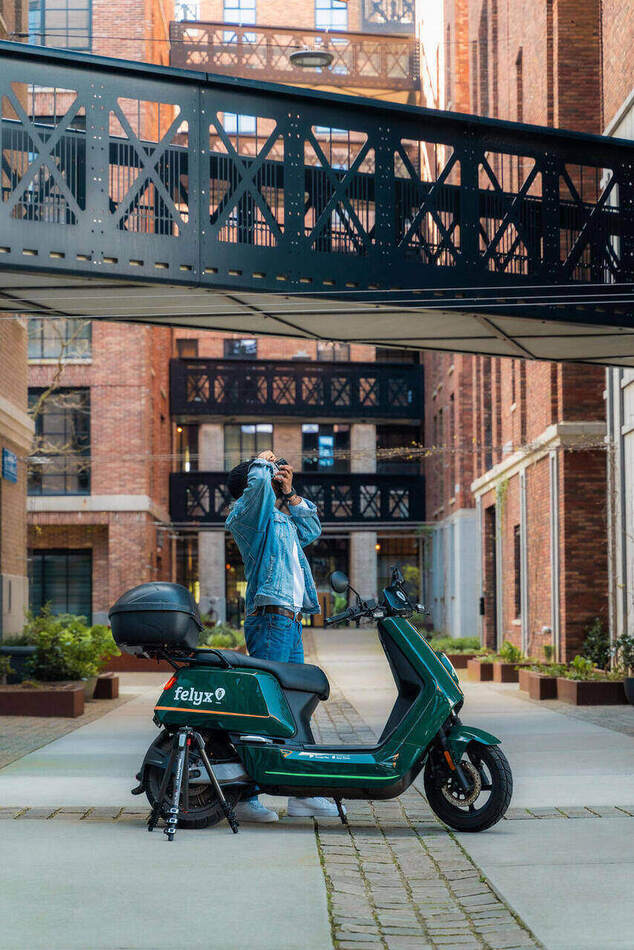 Spring Campaign — fotograaf met camera bij de deelscooter onder de loopbrug
