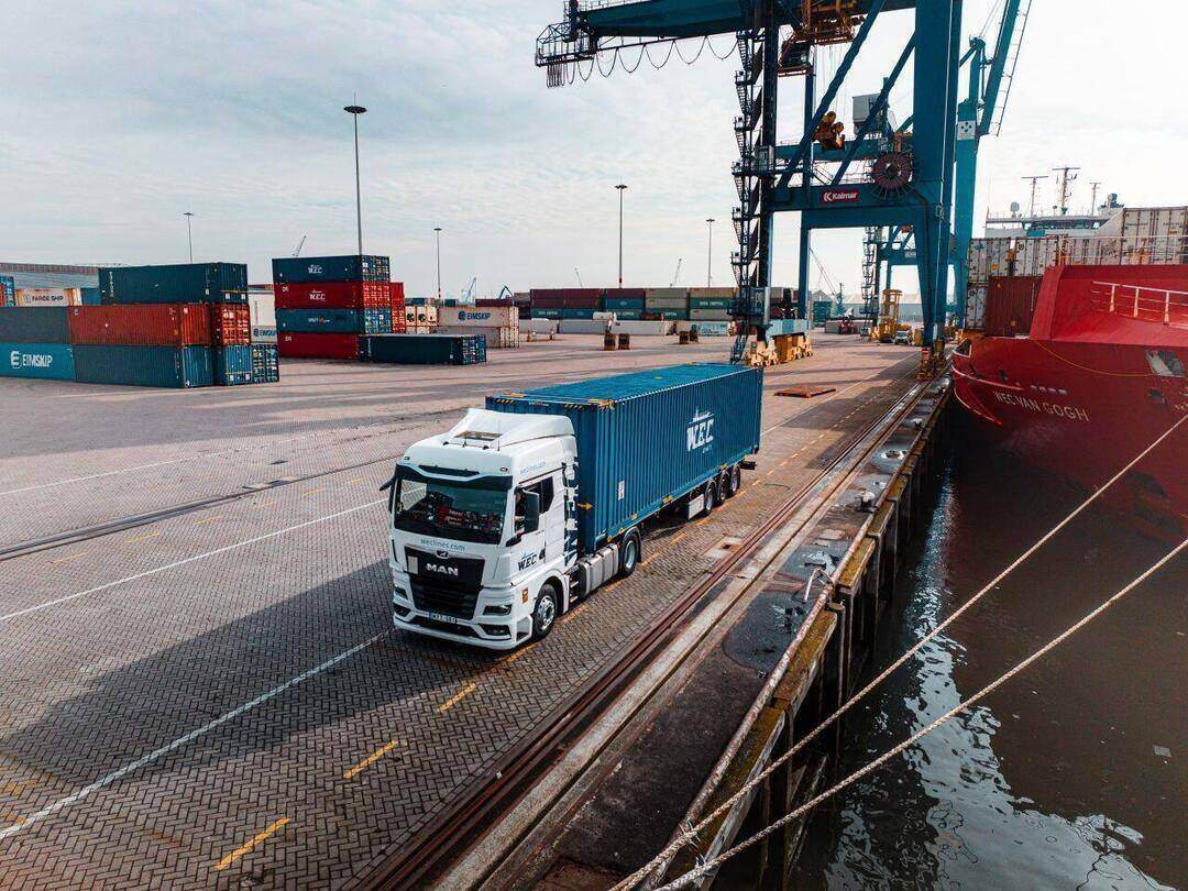 Dronefoto — vrachtwagen met WEC-container op de kade naast de WEC Van Gogh