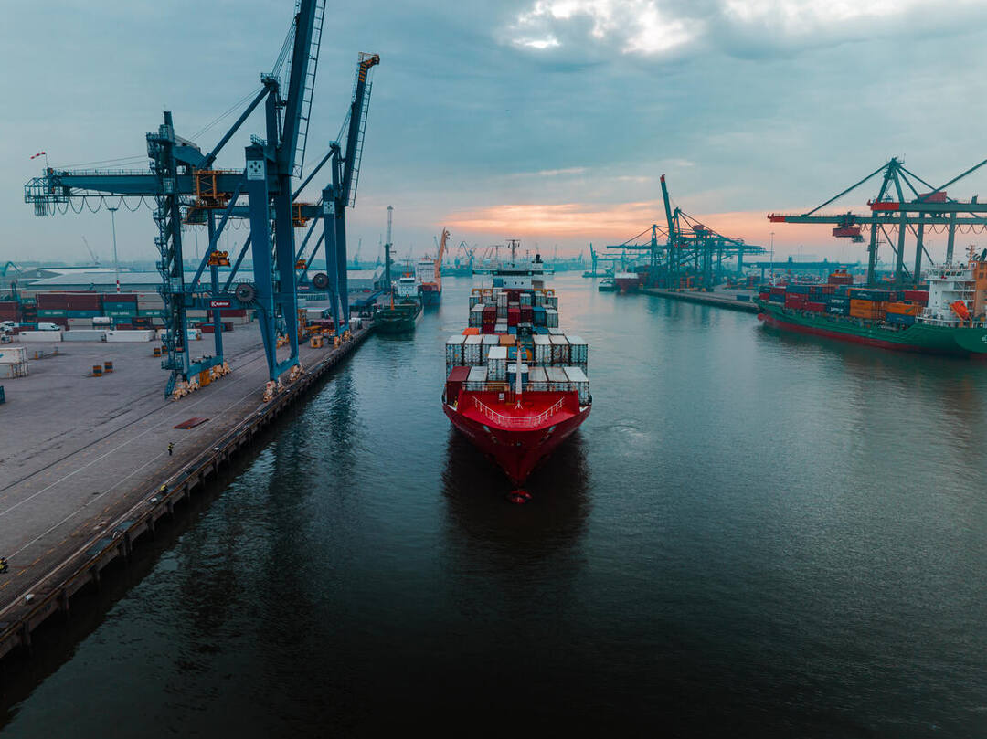 Dronefoto — het schip recht van voren tussen de havenkranen