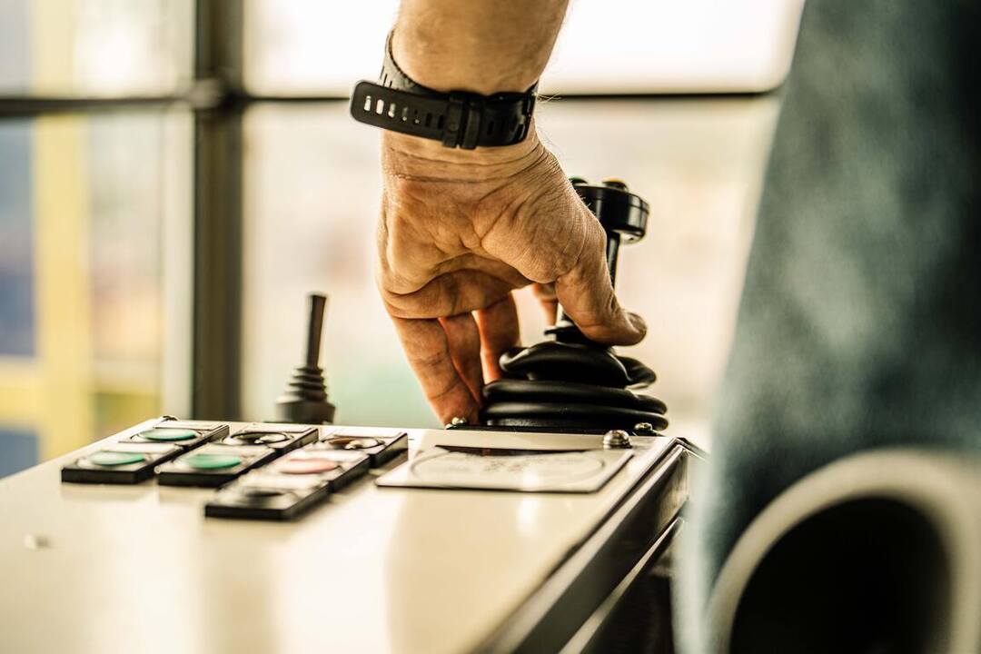 Detail — hand op de joystick van de containerkraan